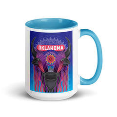 Ceramic mug with black handle and a vibrant illustrated bison decorated with an Indian Blanket wildflower and downtown Oklahoma City. Line one text reads 