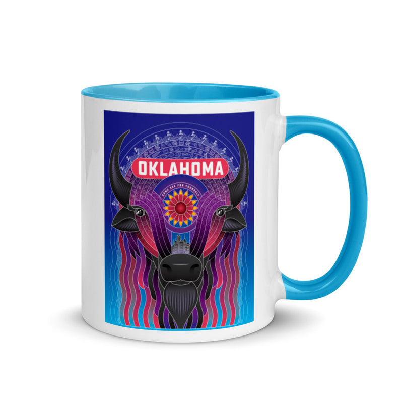 Ceramic mug with blue handle and a vibrant illustrated bison decorated with an Indian Blanket wildflower and downtown Oklahoma City. Line one text reads "Oklahoma." Line two text reads "Come See For Yourself." Right view.